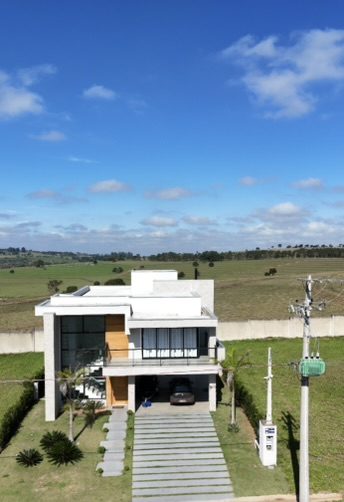 Vista frontal da Casa Moderna de Alto Padrão, com garagem coberta e caminho de placas de concreto no jardim