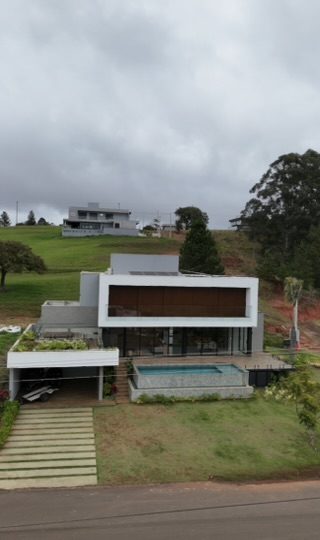 Vista lateral da Casa de Campo em Steel Frame, mostrando o volume suspenso e o jardim no terraço