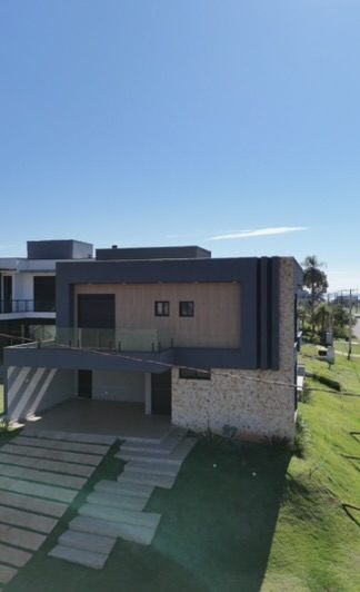 Vista frontal da casa de 259 m² em Steel Frame, com garagem coberta e acesso em placas de concreto