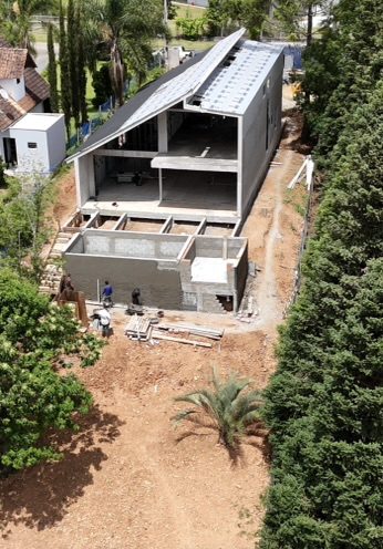 Vista aérea da obra da casa de campo, com a estrutura da piscina e a laje concluídas